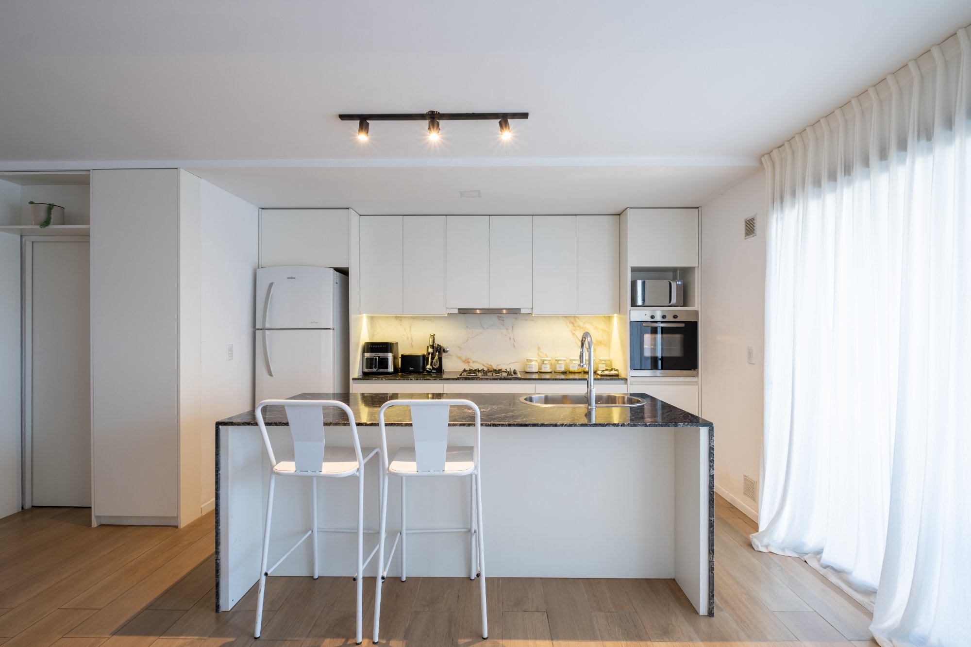 Cocina a medida — melamina blanca con isla